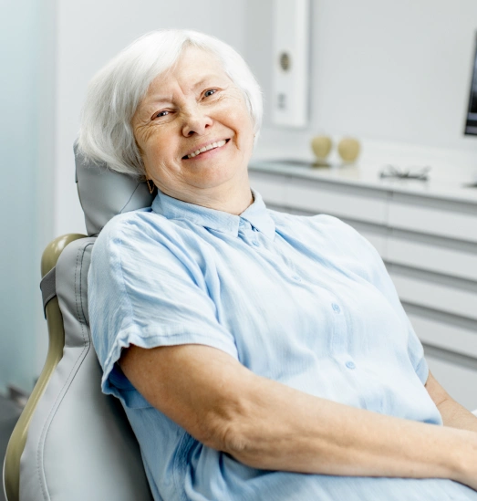 Elderly woman smiling in dental chair at Smith & Co. Dental Practitioners office.